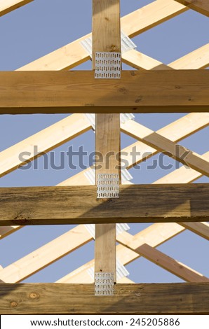 Building contractor carpenter placing new home wood engineered trusses on a residential construction site