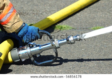 A large straight steam nozzle attached to a 3 inch hose for exposure protection at a structure fire.