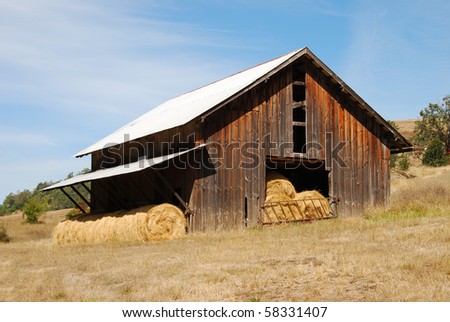 Old barn and roll bales of grass hay in storage along Melton Road near Roseburg Oregon