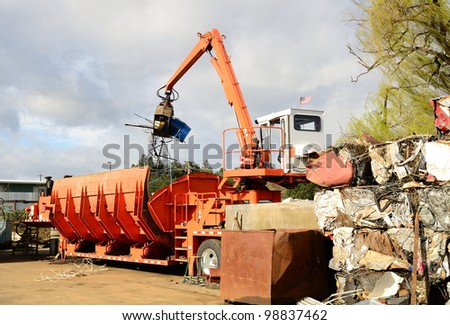 Self contained loader crusher unit processing low grade metal into blocks for further recycling