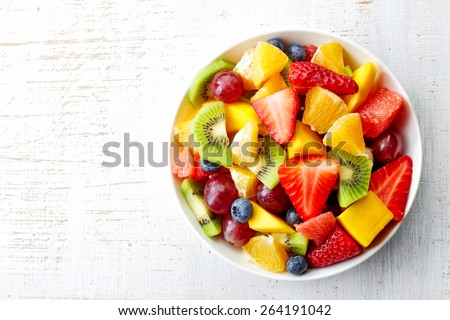 Bowl of healthy fresh fruit salad on wooden background. Top view. 商業照片 © 