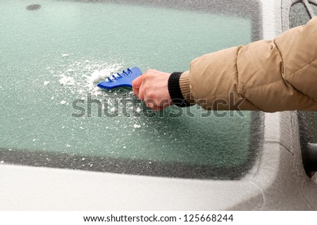 The driver tries to clean auto glass iced
