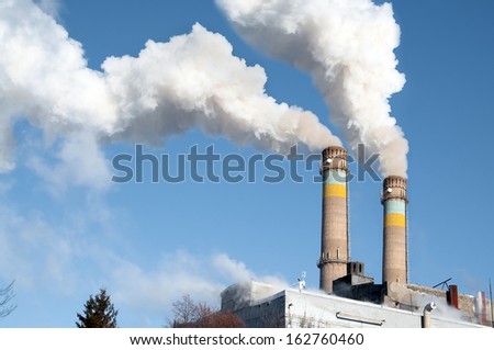 Coal-fired power plant. Thick smoke pipe goes from the atmosphere.