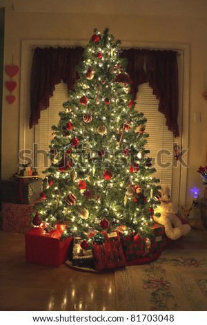 Home with lighted Christmas tree, presents,fireplace,stockings