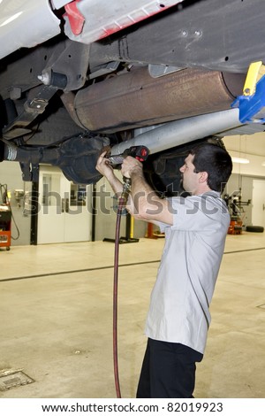 Mechanic removing drive shaft from pickup truck, transmission needs to be replaced