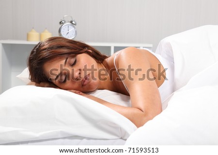 Sleeping beauty in white with alarm clock in background
