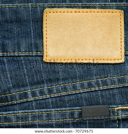 Highly detailed closeup of blank grungy leather label and small dark cotton label on striped blue denim, good for background