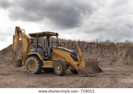 Backhoe on a pile of dirt