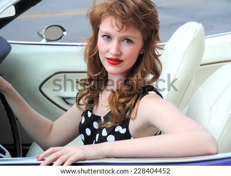 Classic female beauty driving her convertible car.