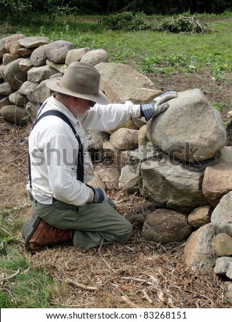 Home owner building a stone wall on his property.