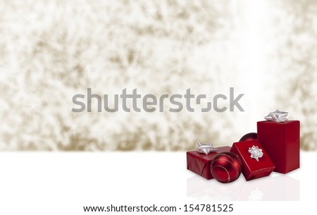 Red gifts with white bows and red and gold ornaments against a sparkling gold background.  Copy space for your own text.