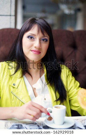 girl sitting in the outdoor cafe and drink coffee