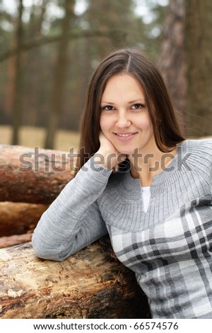 Young woman outdoors in forest lying on a wood log pack