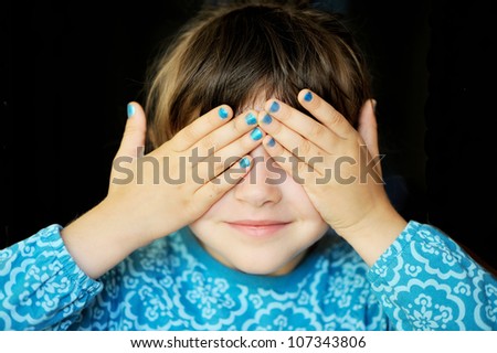 Little girl with her hands covering her eyes, see no evil