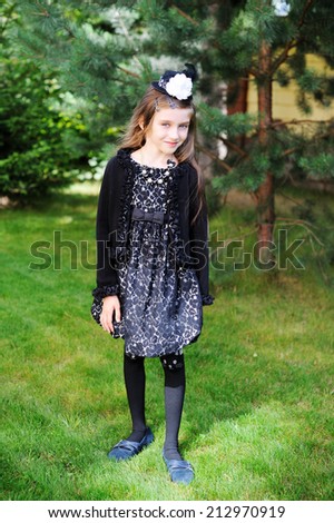 Happy little girl in Halloween outfit having fun in the garden