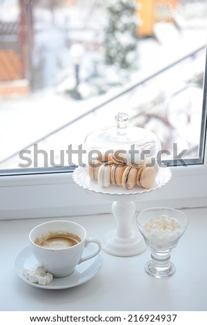 Coffee and sweets on the window with winter view