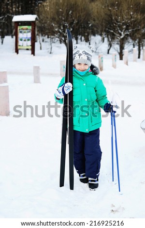 Little girl skiing on cross country skis in the forest on the perfect winter day