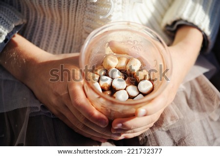 A rich cup of hot chocolate with small marshmallow in kid hands