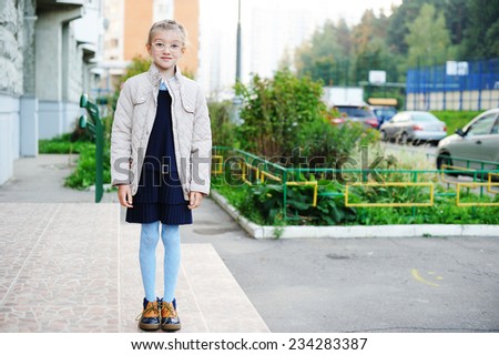 School girl in navy blue uniform on her way to school in the city