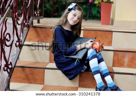 Portrait of Beautiful school girl looking very happy outdoors at the day time. Concept school theme. in blue uniform dress