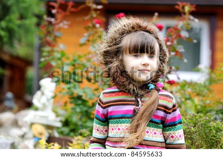 Outdoors portrait of adorable child girl in colorful blouse