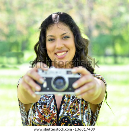 Portrait of beautiful woman taking picture mwith vintage camera