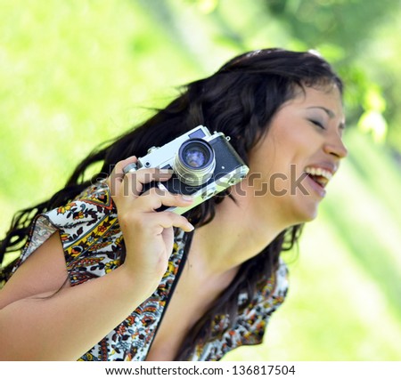 Smiling woman holding vintage camera