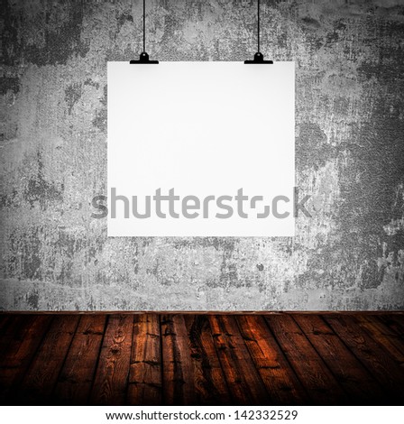 Interior of grunge empty room with white paper hanging on paper clips