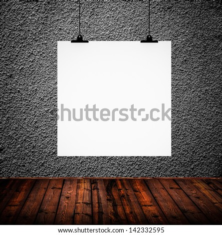 Blank paper hanging on concrete wall in grunge room