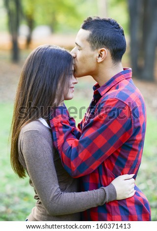 Close up of boy kissing girlfriend on forehead outdoor
