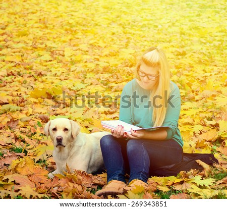 Girl with dog studying in nature