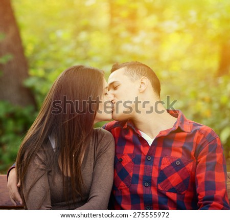 Couple kissing at the bench in park