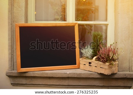 Wooden board for restaurant menu with empty space to add text standing on widnow
