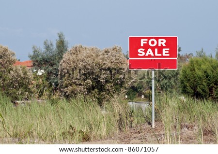 Land for sale sign in empty field