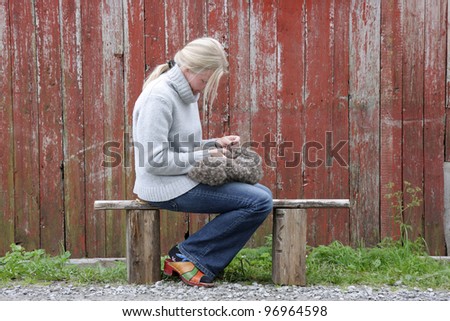 Blond woman sitting on bench, hand-cleaning eiderdown