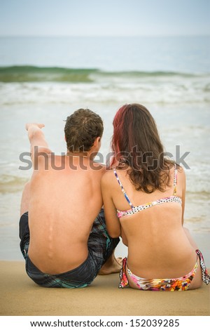 The enamoured couple looks in a sea distance and with enthusiasm talks...