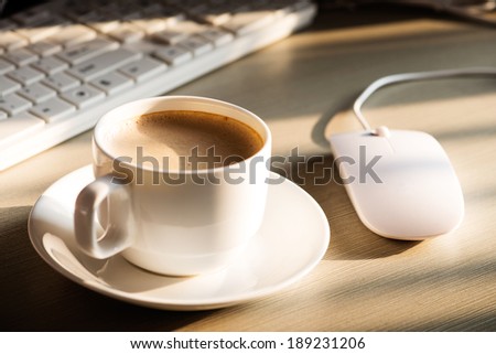 Close-up of the coffee, cellphone, pen and a cup of keyboard on the desktop