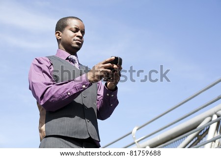 Black business man with modern smart phone, outdoor with blue sky