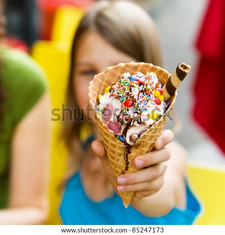 Little girl showing ice cream at camera