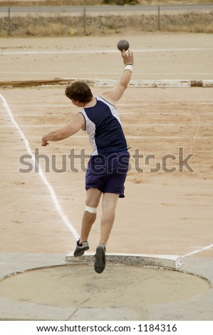 A competitor in the men\'s shot put event during a college track meet.