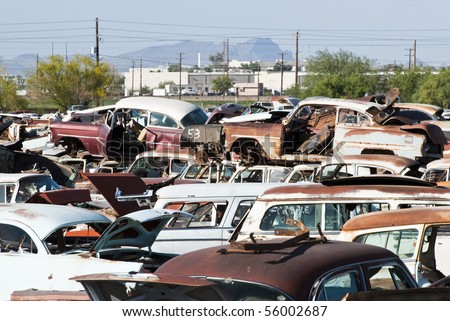 old vehicles in an auto salvage yard being recycled for parts and scrap metal