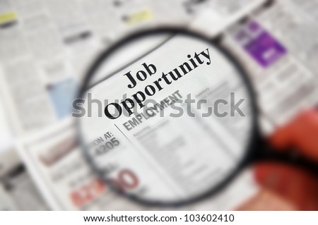Magnifying glass over a newspaper classified section with \