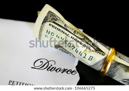 Divorce decree and rolled up cash in a wedding ring