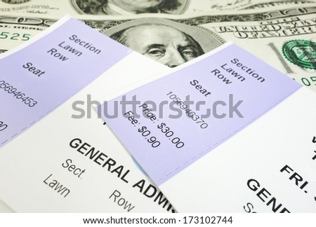 closeup of two concert tickets and cash