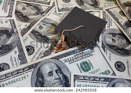 Miniature graduation cap with Student Loans text, on assorted cash