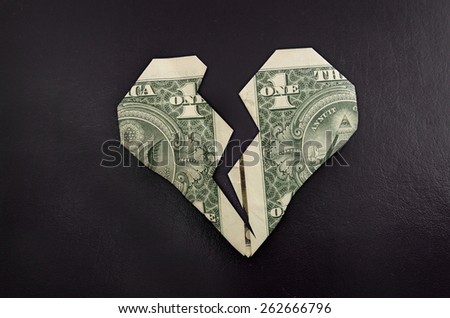 A broken origami dollar heart, on black textured background