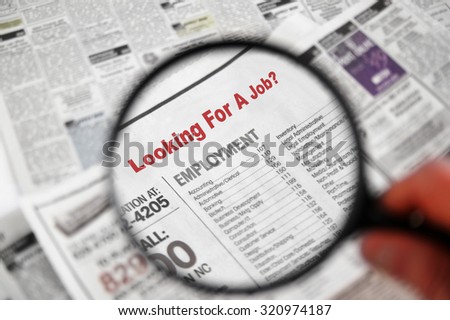 Magnifying glass over Jobs section of newspaper classifieds