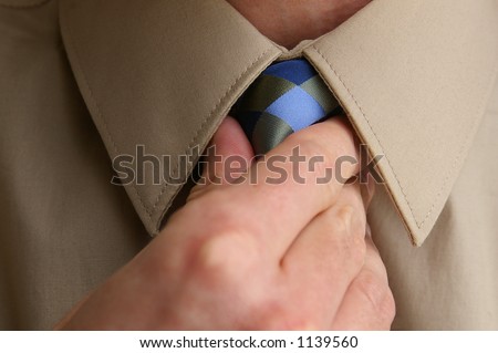 Man adjusting tie