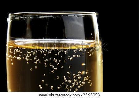 Champagne glass with bubbles on dark background. Could also be used as beer.