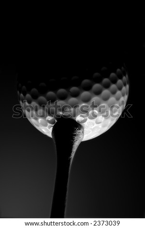 Golf ball on a tee shot from below in black and white